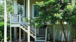 A two-story house with a porch and a staircase. - Villa in Wild Dunes with golf and Lagoon views; close to pool (Isle of Palms)