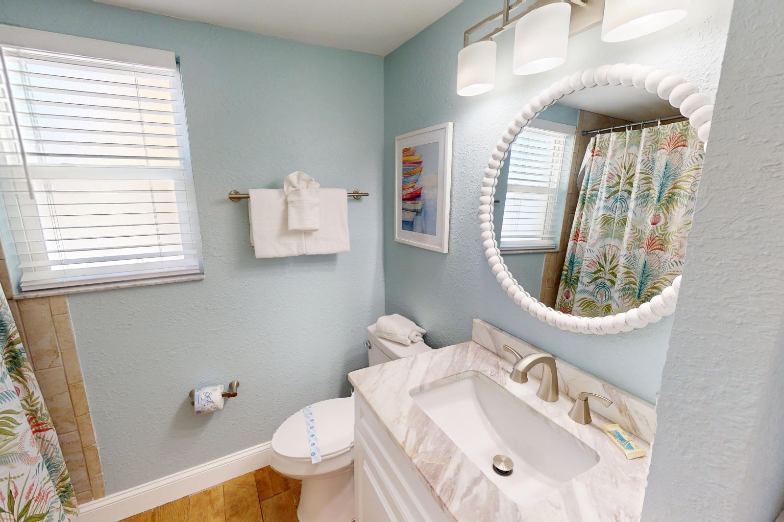 A bathroom with a toilet, sink, and mirror.