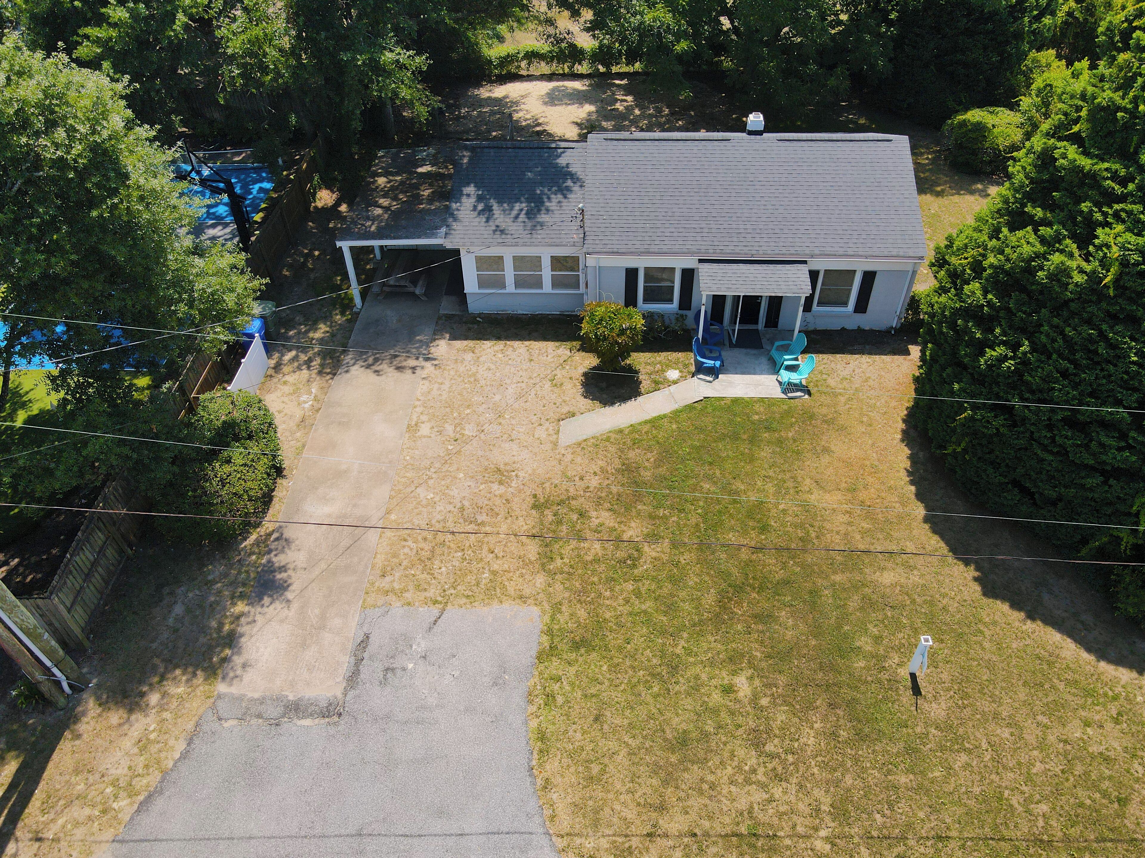 A single-story house with a front porch, a small yard, and a driveway.