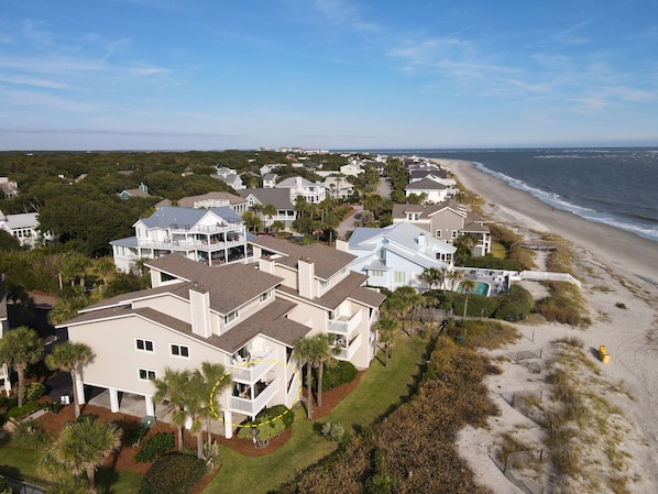 Une zone résidentielle côtière avec des maisons, une plage et un ciel dégagé.