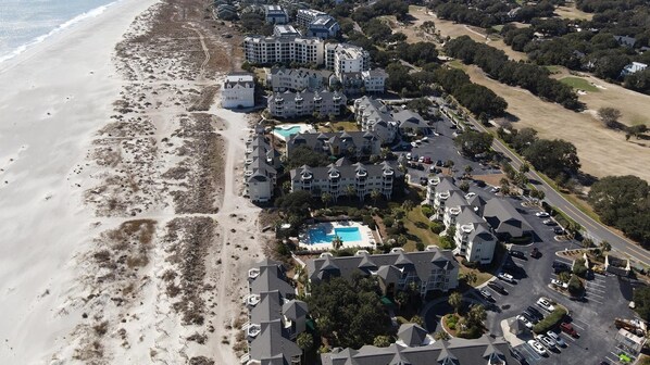 An aerial view of a coastal hotel with multiple buildings, a swimming pool, and a beach. - Ocean View condo in Wild Dunes (Isle of Palms)