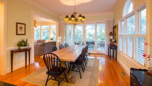 A spacious dining area with a long wooden table, multiple chairs, and a chandelier. - Beautifully decorated and spacious home in Wild Dunes with a private pool (Isle of Palms)