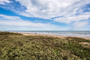 Una playa con cielo despejado y vista al océano.