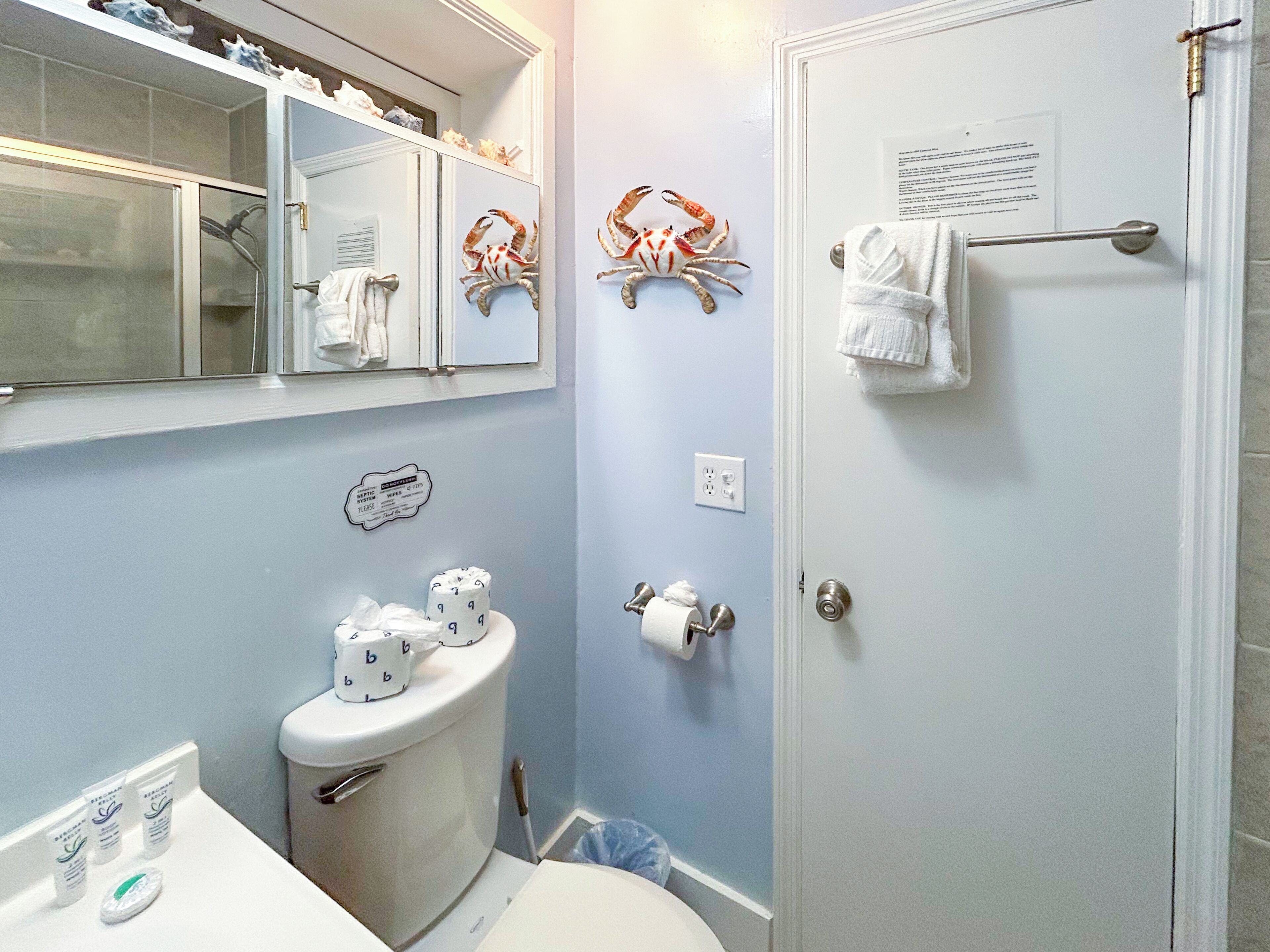 A bathroom with a toilet, sink, mirror, and towel rack.