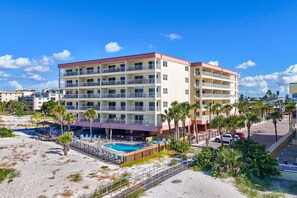 A multi-story hotel with balconies, a swimming pool, and a beach area. - Awesome Beach & Gulf Views - Madeira Norte #111 (Madeira Beach)