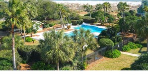 Una piscina envoltada de palmeres amb vista a l'oceà.