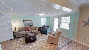 A living room with a beige sofa, a blue armchair, and a coffee table.