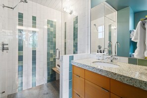 A modern bathroom with a shower, a sink, and a mirror.