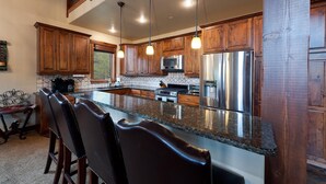A spacious kitchen with wooden cabinets, stainless steel appliances, and a large granite island. - Home Across from Purg - Views, Deck/Fire Pit/Ping Pong/Shuffleboard (Durango)