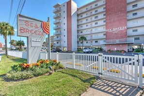 En hotelindgang med et skilt, der viser "Sea Breeze of Madeira", og en indkørsel med låge.