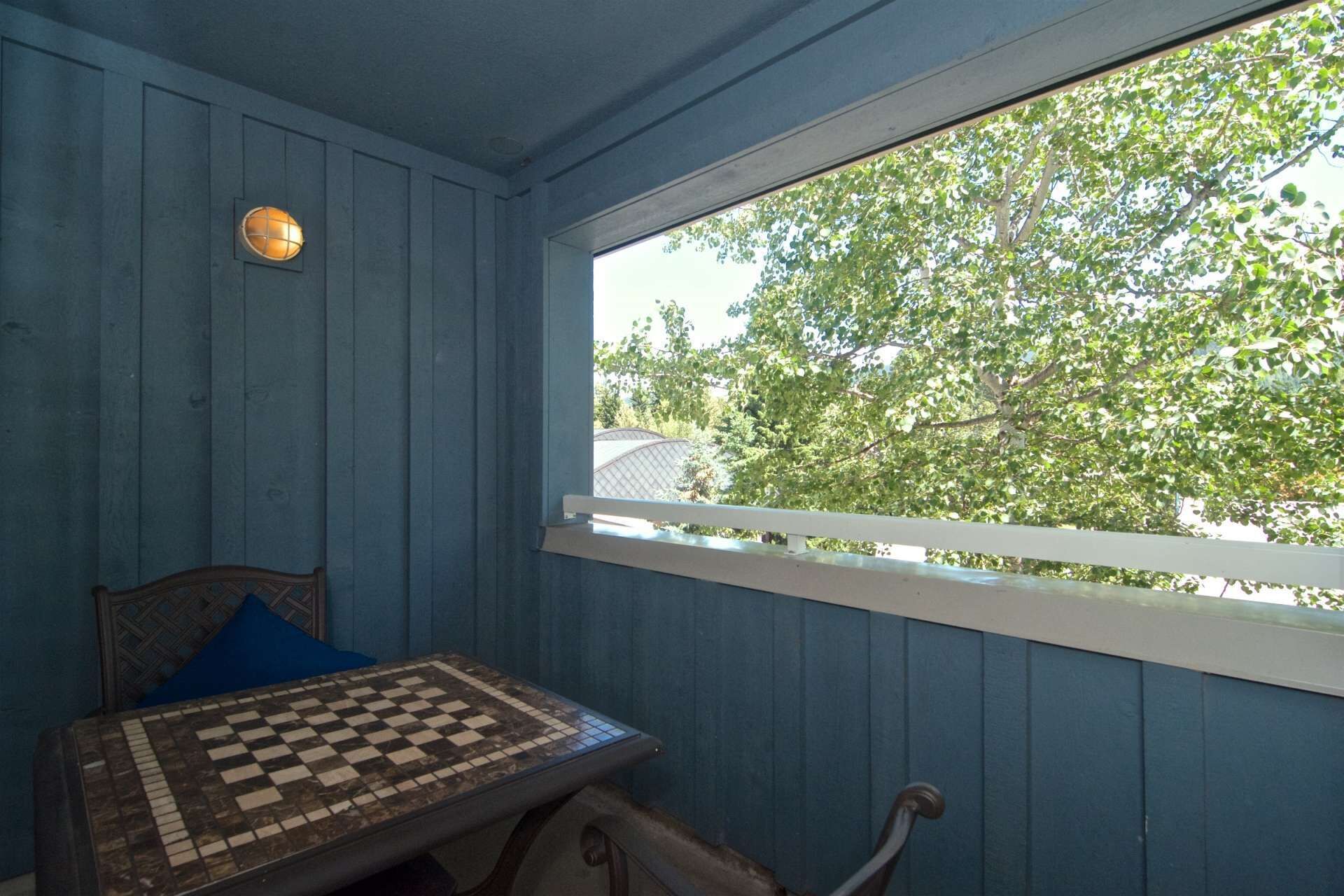A room with a chessboard on a table, a window with a white frame, and a door with a wooden handle.