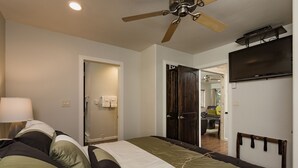 A bedroom with a bed, a ceiling fan, a TV, and a door leading to another room. - Completely Remodeled Ski in/Ski Out condo - Amazing Views and Great Deck (Durango)