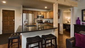 A modern kitchen with a central island, stainless steel appliances, and wooden cabinets. - Completely Remodeled Ski in/Ski Out condo - Amazing Views and Great Deck (Durango)