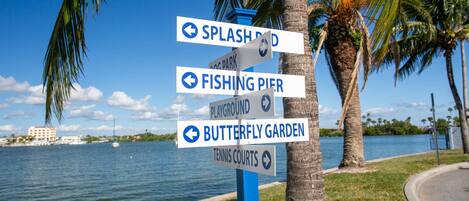 A signpost with directions to Splash Park, Fishing Pier, Playground, Butterfly Garden, and Tennis Courts.