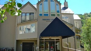 A multi-story building with a sign reading "VIKING LODGE." There are bicycles parked outside, a covered entrance, and a clear sky in the background. - Chic, Modern | Walk Anywhere @ Viking Lodge 206 (Telluride)