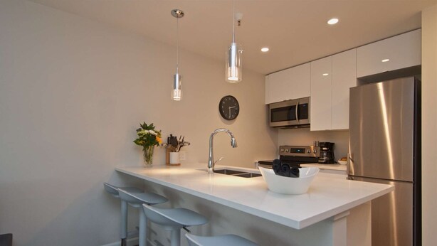A modern kitchen with a central island, stainless steel appliances, and pendant lighting. - Renovated, Village location. Walk to lifts ,amenities, modern décor, hot tub closed for renovation. (Whistler)