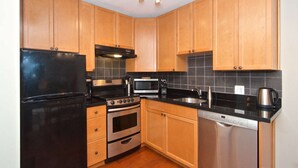 A kitchen with wooden cabinets, a black refrigerator, a stove, a microwave, and a dishwasher. - Charming Creekside Townhouse. Easy WALK to the Gondola. Professionally Managed + Cleaned (Whistler)