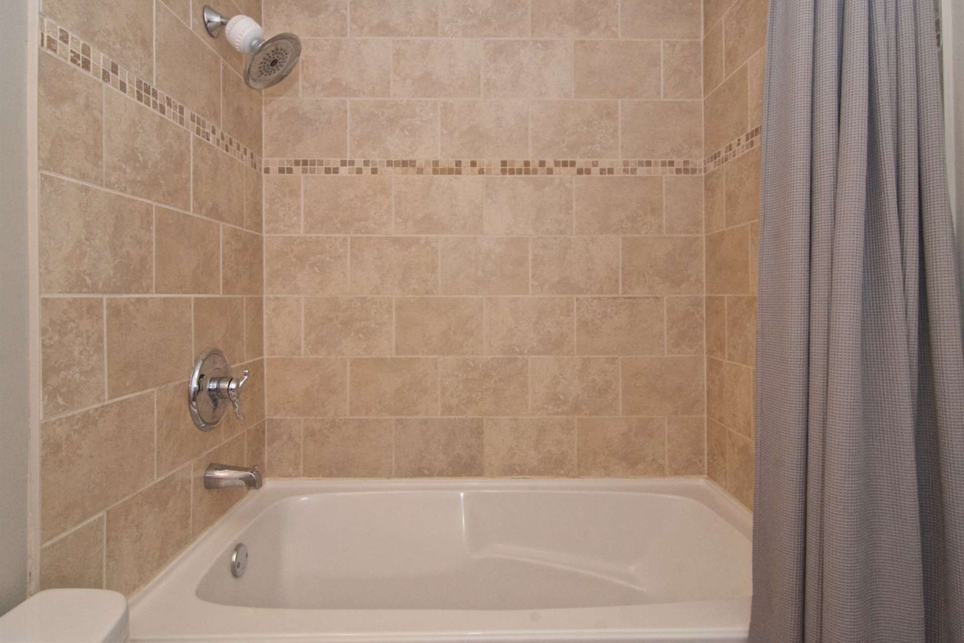 A bathroom with a bathtub, shower, and toilet.