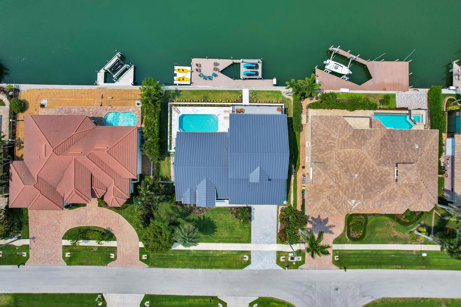 An aerial view of a resort with multiple buildings, swimming pools, and a marina.