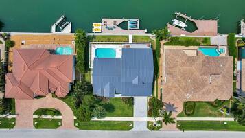 An aerial view of a resort with multiple buildings, swimming pools, and a marina.