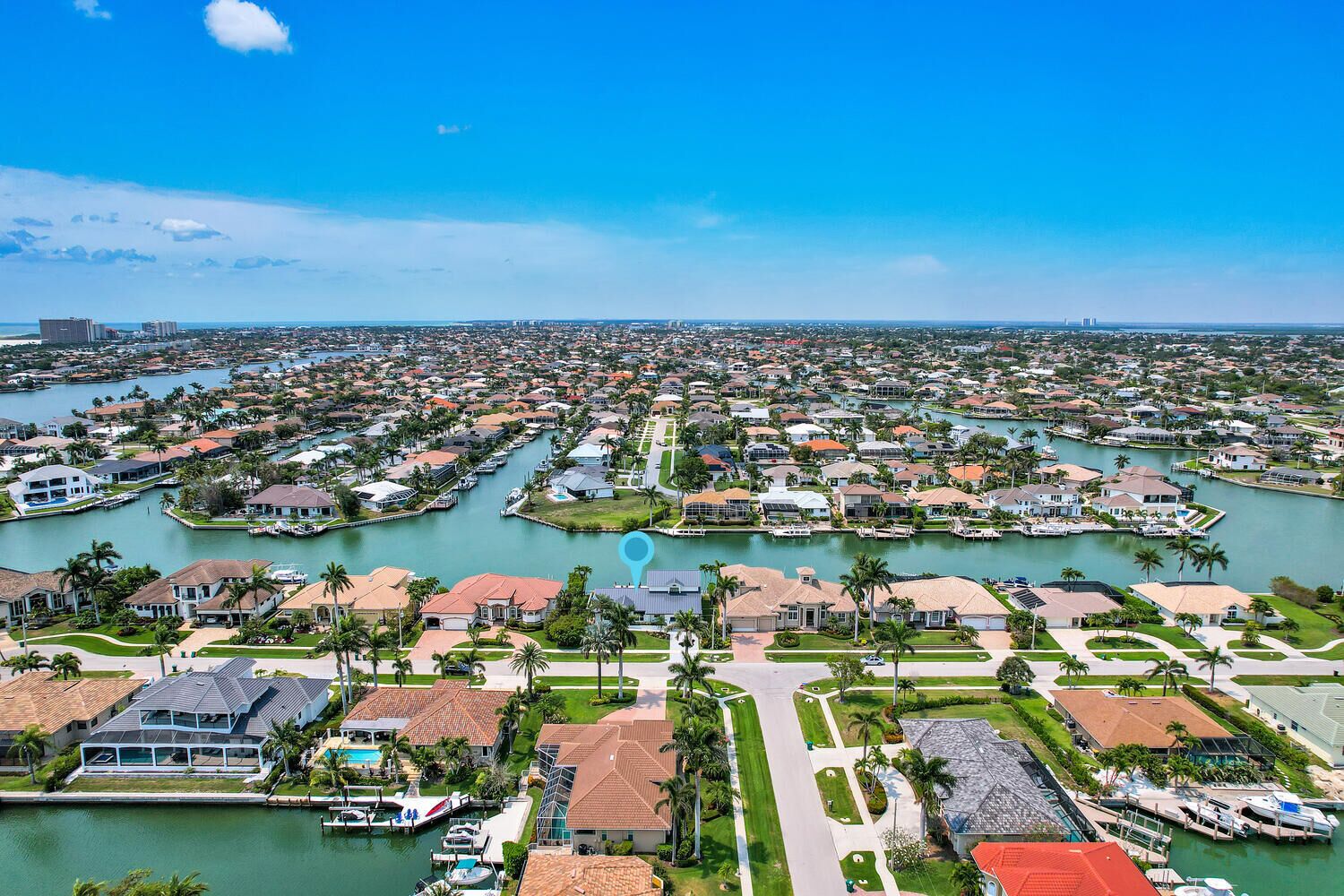 A residential area with houses, a marina, and a large body of water.