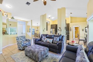 Relax in this stylish living room with a comfortable sofa, ottoman, and armchair, perfect for unwinding.