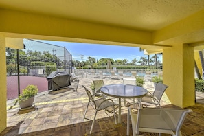 Relax and socialize in our outdoor patio area, featuring a round table, comfortable seating, and a shaded retreat.