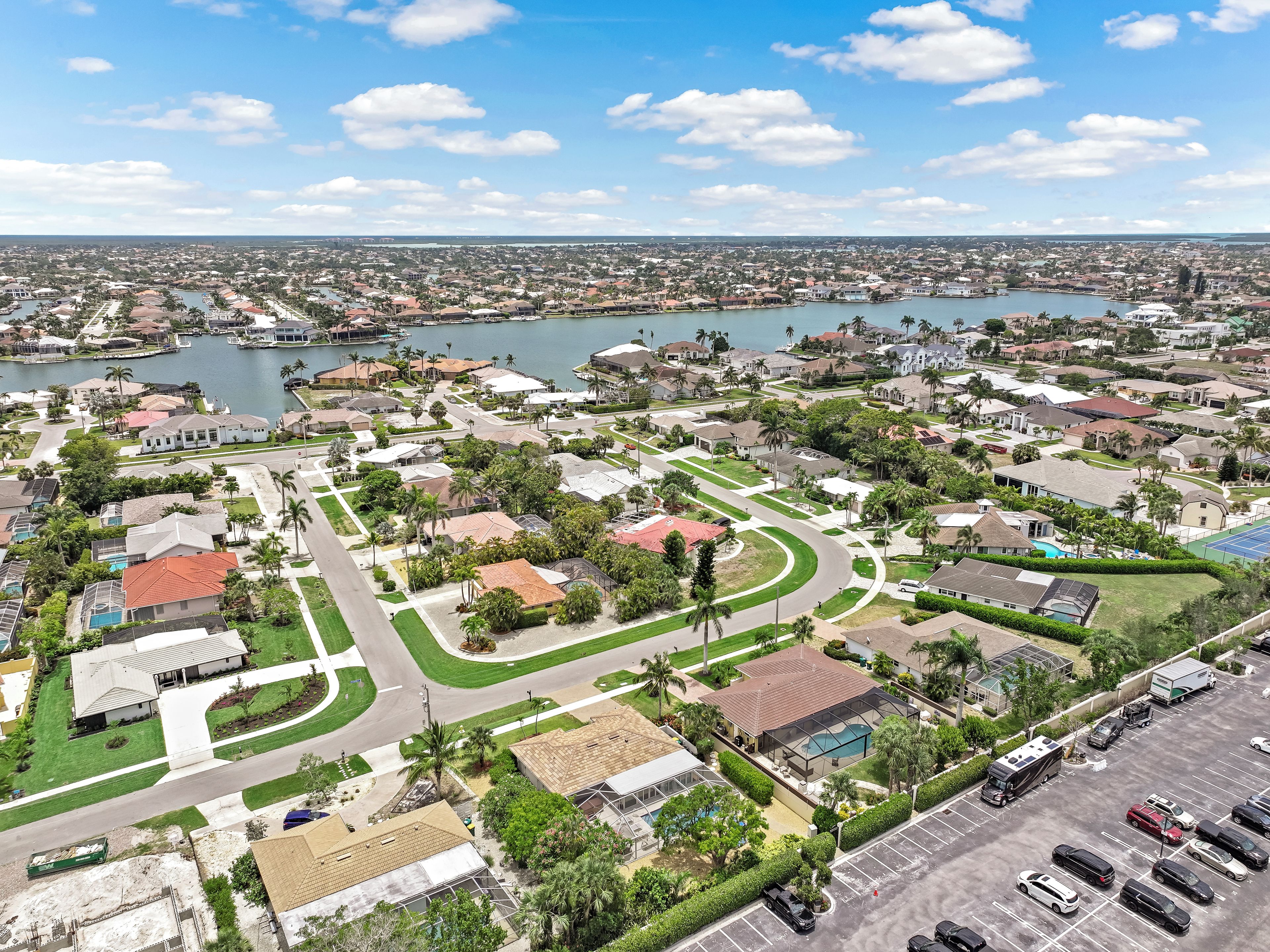 An aerial view of a residential area with houses, roads, and a body of water.