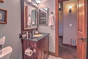 A bathroom with a wooden vanity, a sink, a mirror, and a towel rack. - Private Deck & Community Pool: Incline Village Gem (Incline Village)
