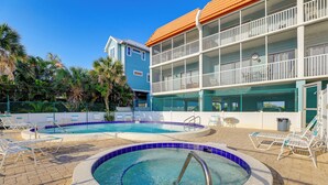 A hotel with a pool area, including a hot tub and lounge chairs. - Gulf Views & Pool Access: Bradenton Beach Condo! (Bradenton Beach)