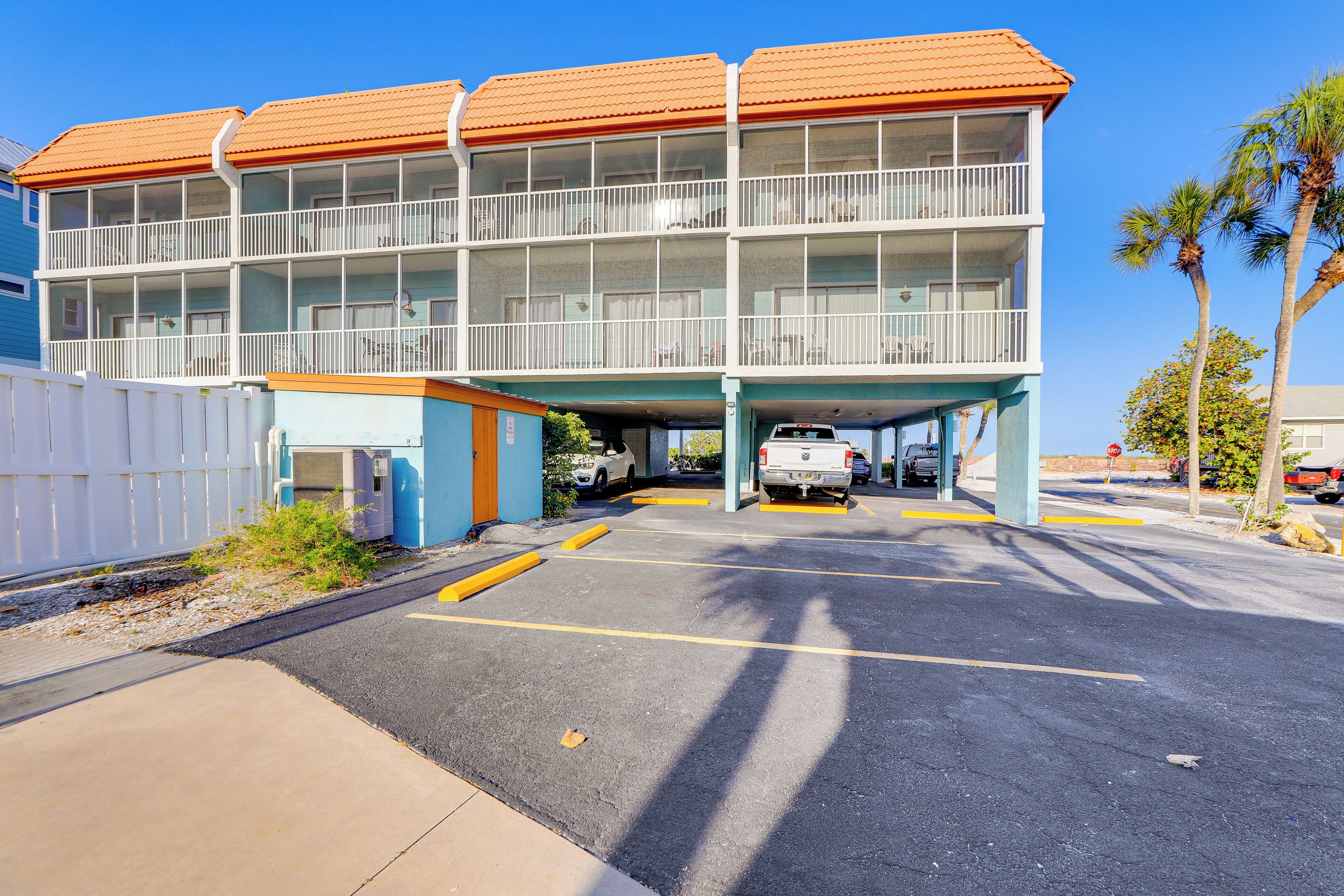 Un motel a più piani con un'area di parcheggio di fronte.