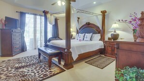 A four-poster bed with a canopy, a wooden bench, a television on a dresser, and a decorative vase with flowers. - Upscale Marco Island Villa w/ Outdoor Bar + Pool! (Marco Island)