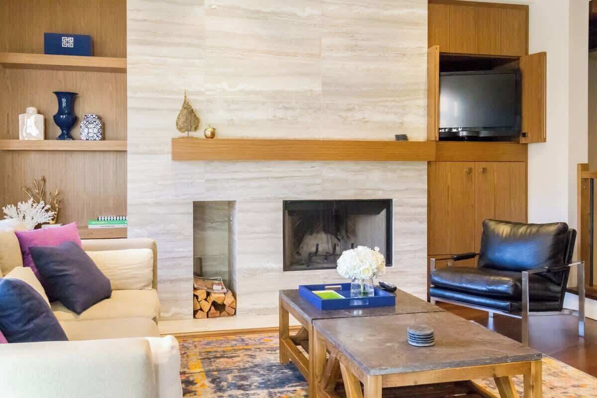 A modern living room with a fireplace, a television, a sofa, and a coffee table.