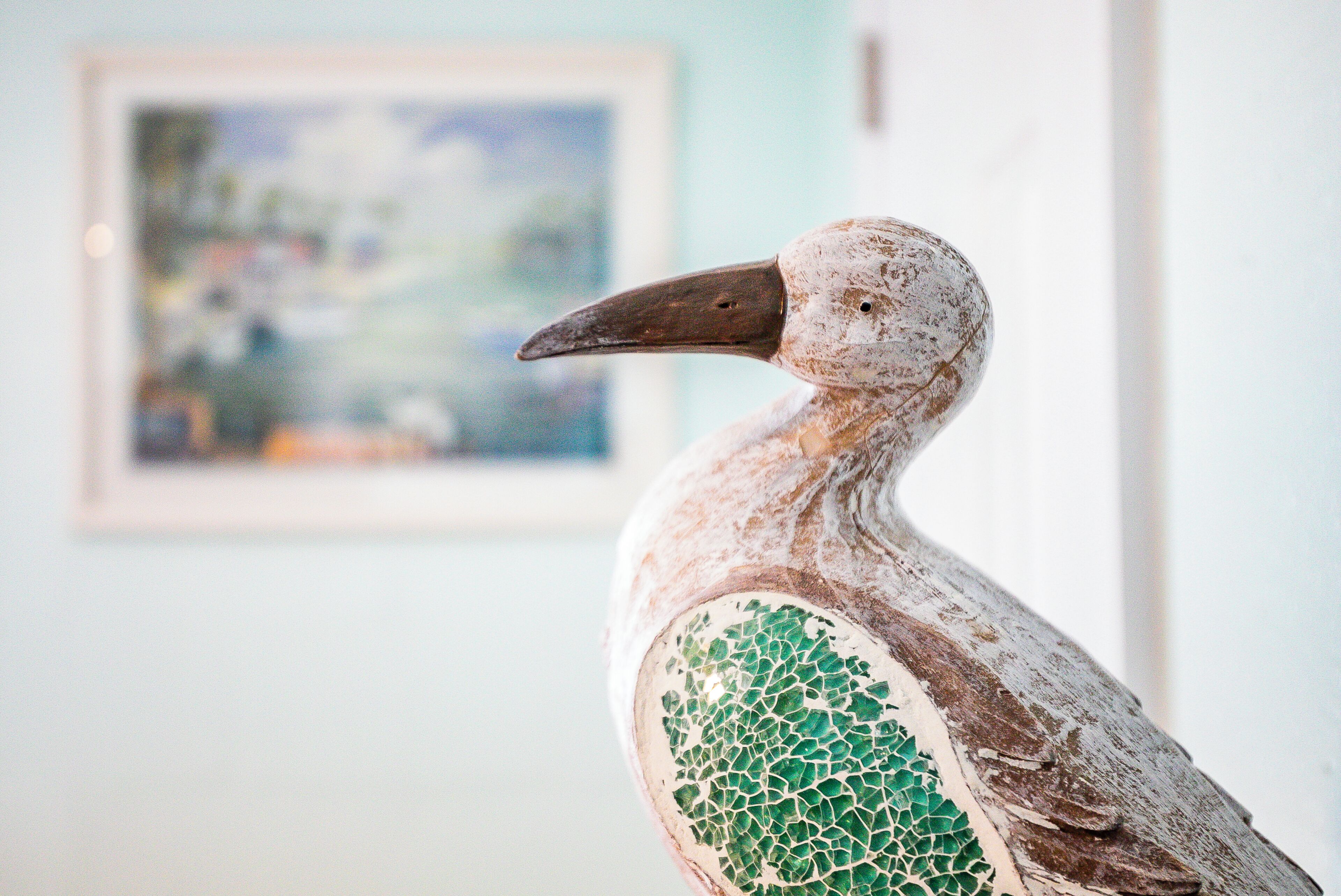 A bird sculpture with a mosaic pattern on its body.
