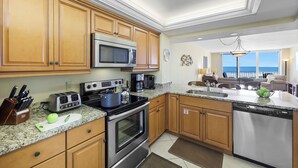 A modern kitchen with wooden cabinets, a stainless steel microwave, a stove, and a dishwasher.