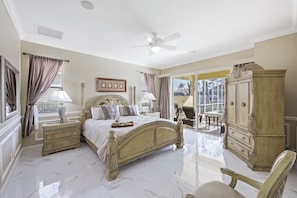 A spacious bedroom with a large bed, a wardrobe, and a view of the outdoors.
