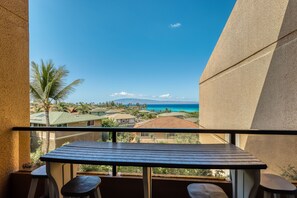 Enjoy the serene ocean views from this balcony with a table and two chairs.