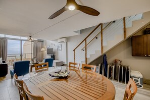 Relax in this spacious living area with a round dining table, ceiling fan, and comfortable seating areas.