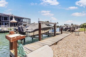 Un muelle con barcos, una zona cubierta y un edificio con grandes ventanales.