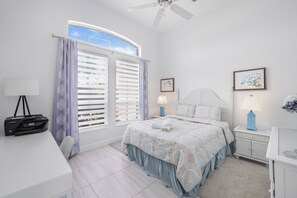 Une chambre à coucher avec un lit, un bureau, une imprimante et une fenêtre avec des volets.