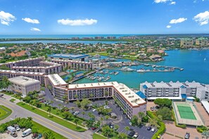 A coastal hotel with multiple buildings, a marina, and a road leading to the property.