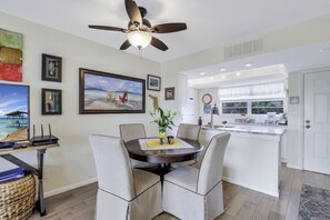 A modern kitchen with white cabinets, a built-in oven, and a countertop with a coffee maker. - Island-Style Condo | Pool, Spa & Steps to Beach (Marco Island)