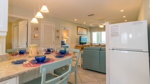 Una cocina moderna con comedor, refrigerador y televisor.