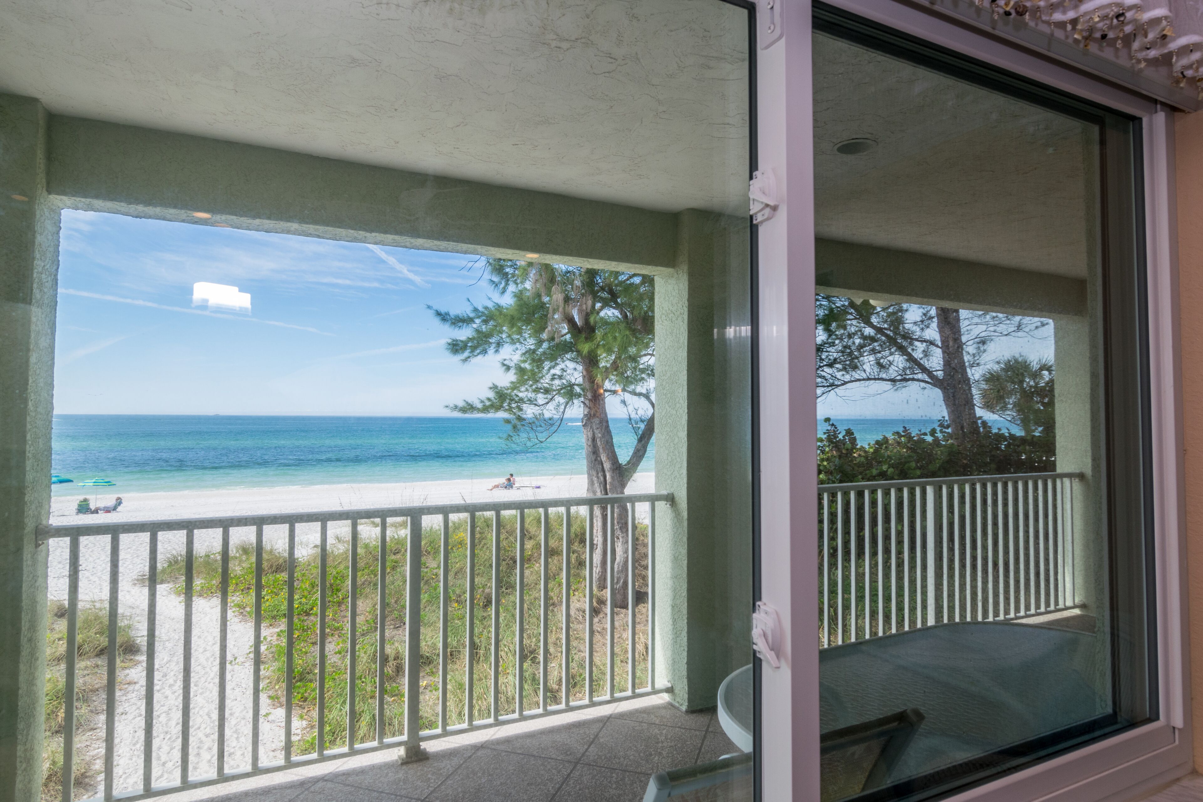 Un balcon avec vue sur la plage et l’océan.