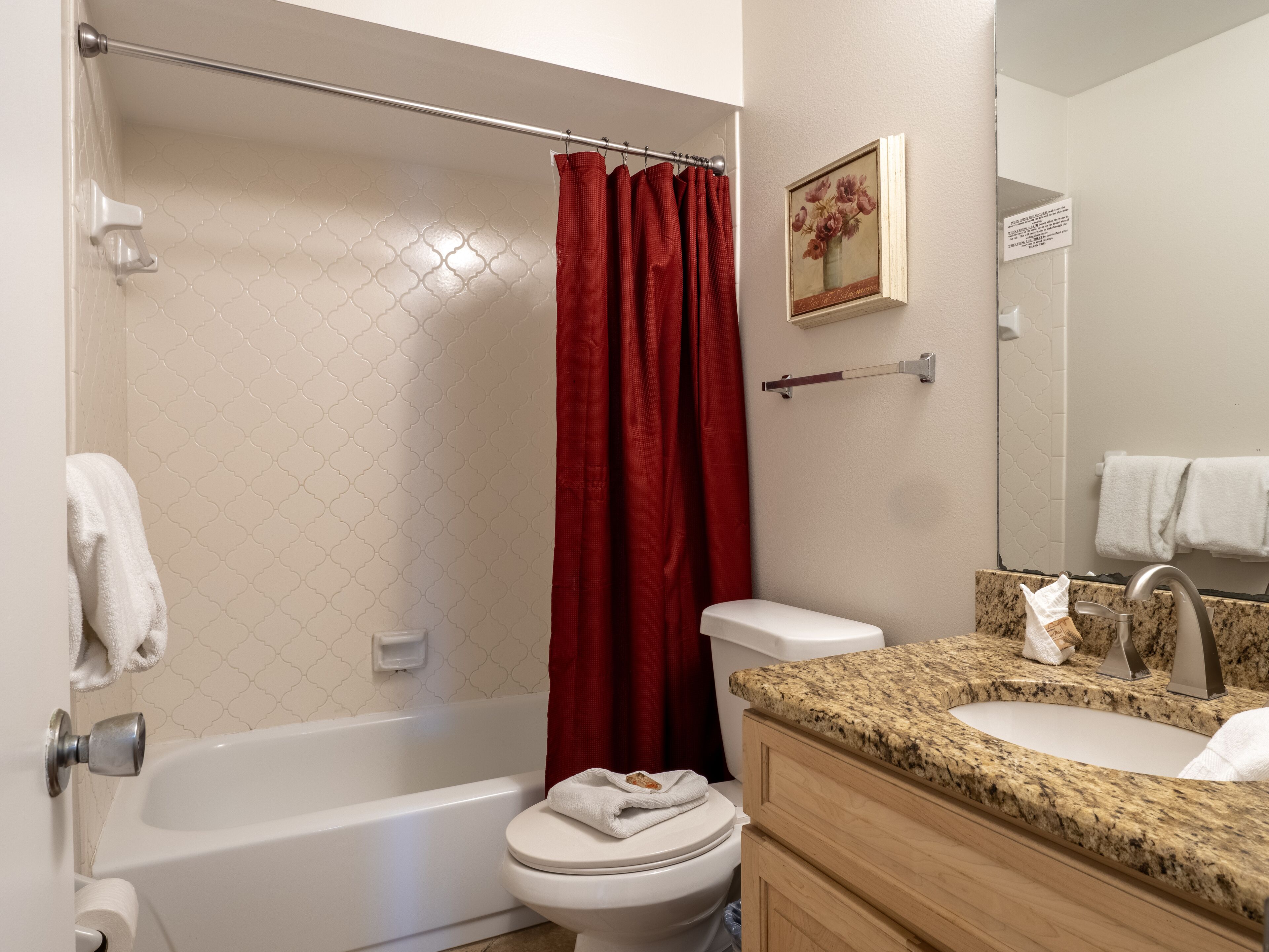 A bathroom with a bathtub, toilet, and sink.