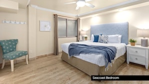 A bedroom with a bed, nightstands, a chair, a ceiling fan, and a window with curtains. - Ultimate Serene Escape P819-6 (Oceanside)