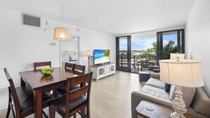 Una sala moderna con comedor, ventanas amplias y vistas al exterior.