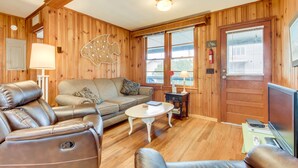 A cozy room with a leather sofa, a small round table, and a television. - Tip Ellen on Pawleys Island - Second Row, Pet Friendly (Pawleys Island)