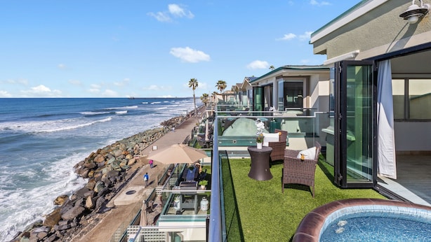A seaside balcony with a view of the ocean, a hot tub, and outdoor furniture. - Spacious Beachfront Family Retreat - 819-4 (Oceanside)