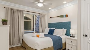 A neatly arranged bedroom with a bed, bedside table, and a window with curtains. - Top Notch Coastal Getaway P813-2 (Oceanside)